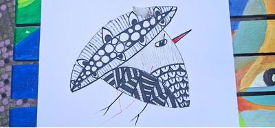 Ayko, a solitary bird with Japanese-inspired textures and a real feather, balanced on Raouche Rocks in the Architecture of Flight essay.